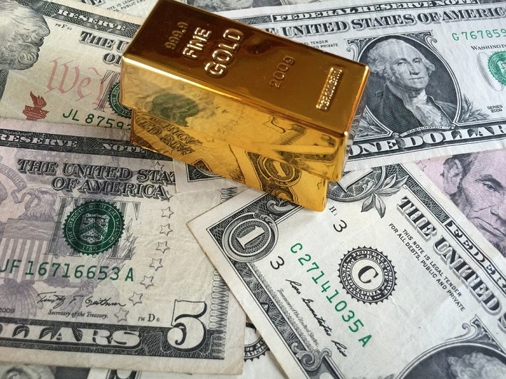 Gold bars sitting on US paper money