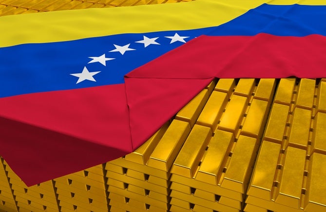 Image of Venezuelan flag drapped over stacks of gold bars
