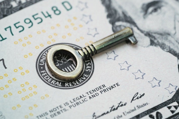 Silver key placed on the paper money
