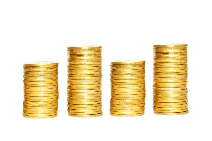 Four neat and varying height stacks of gold coins