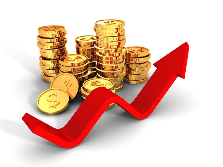 Stacks of gold coins with an arrow indication a fluctuating price.