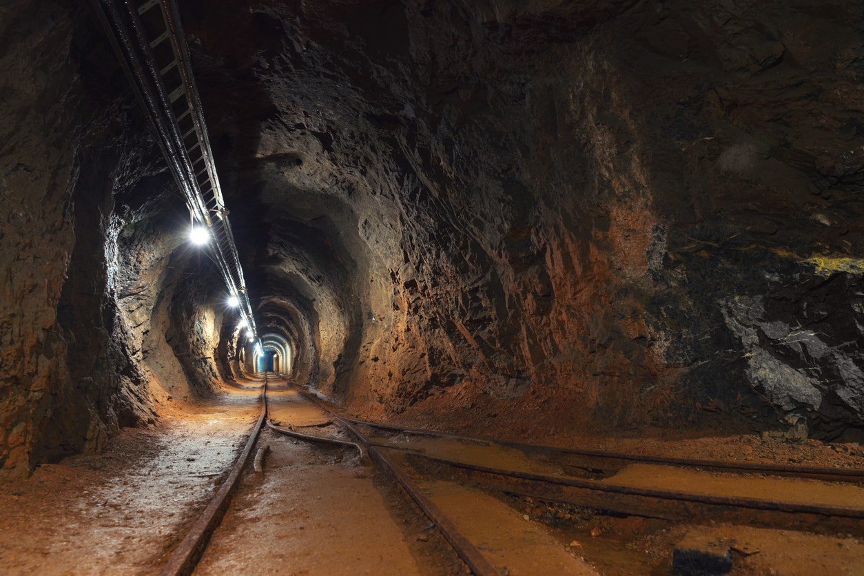 A tunnel with the rail line and a light in it