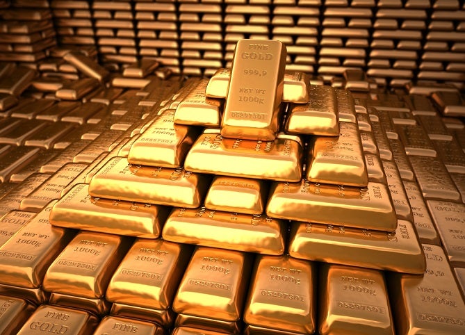 Image of neatly stacked gold bars in a pyramid shaped pile.