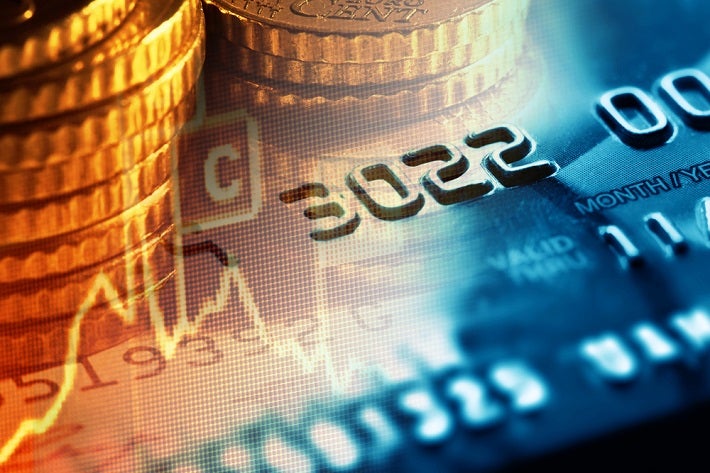 Abstract image of stacked gold coins fading into a credit card