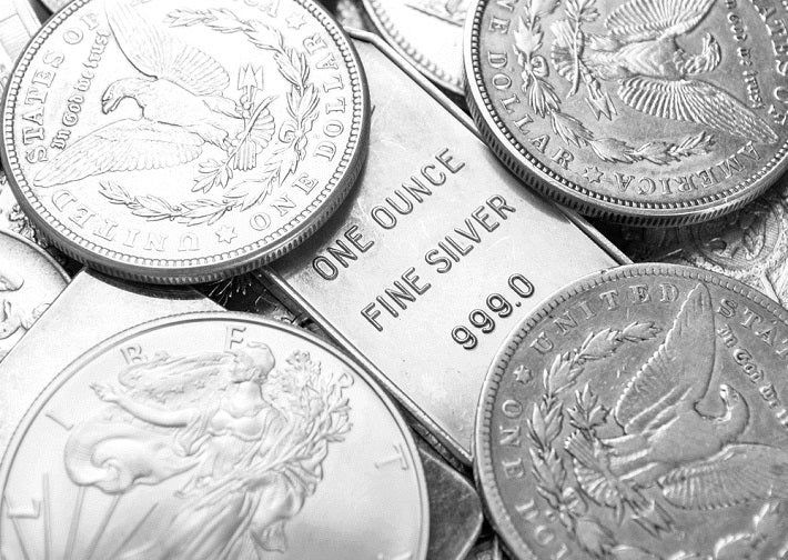 Image shows the silver bar reflected in between the coins