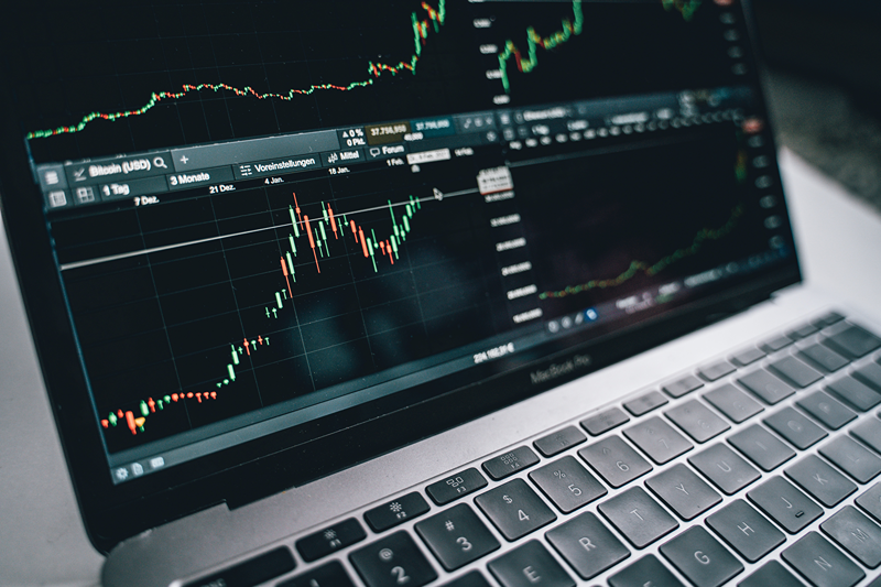 hand pointing at stocks on screen