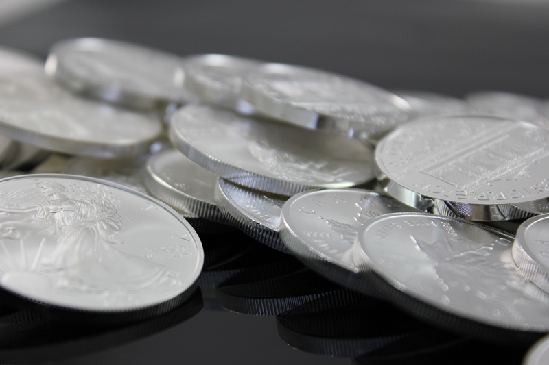silver coins laid on black surface